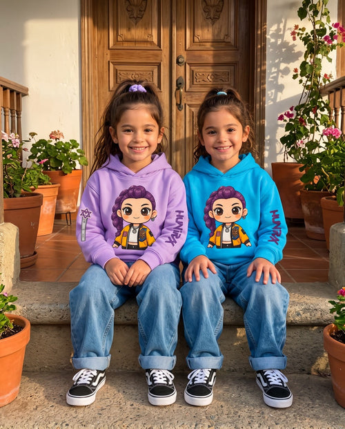 Dos niñas sentadas en el porche con el buzo capota Rumi, una en lila y otra en azul celeste
